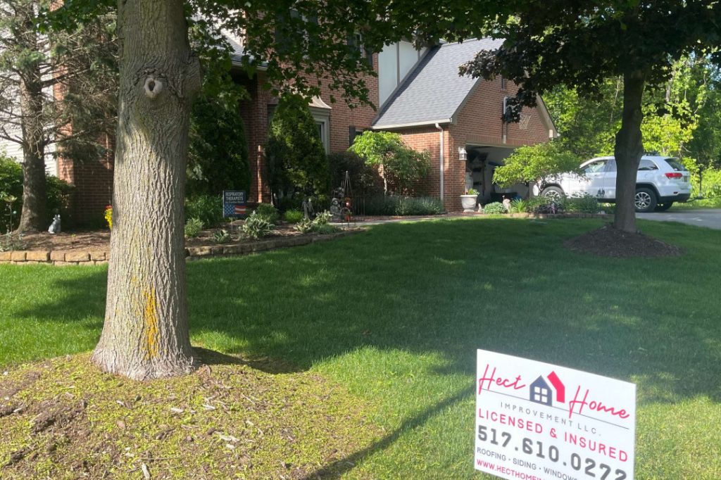 Hect Home sign in front yard of home with a new roof