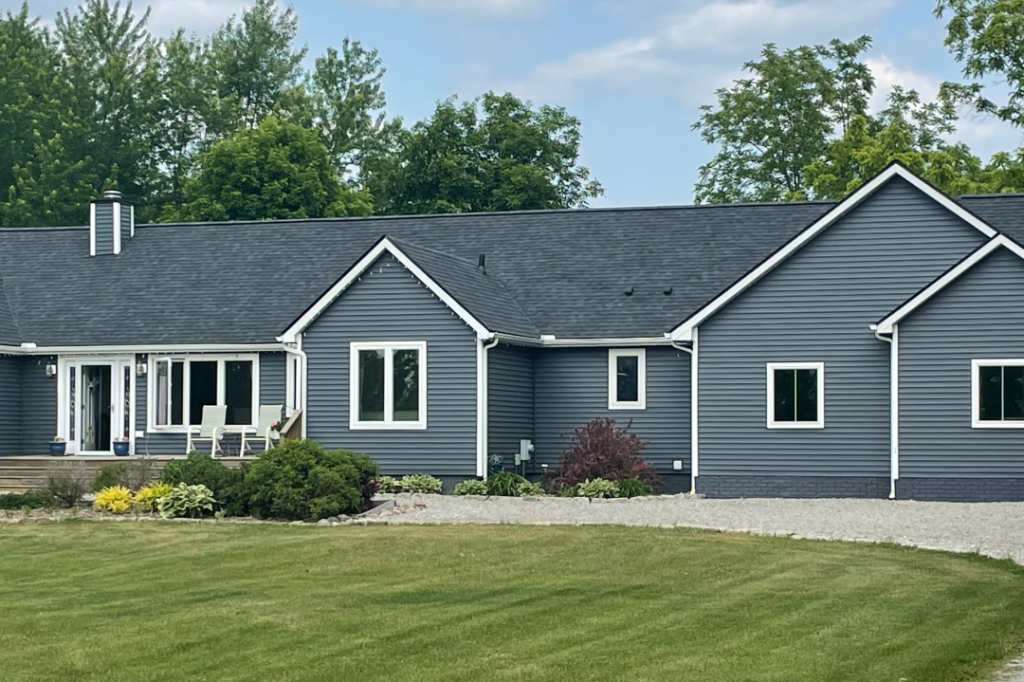 blue sided house with new black roof