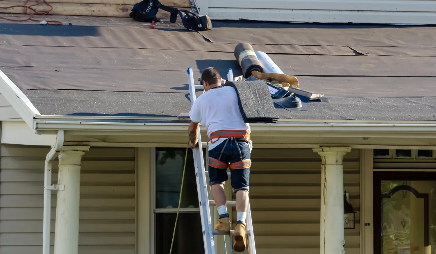 handyman using nail gun to install shingle to repair roof shingle installation